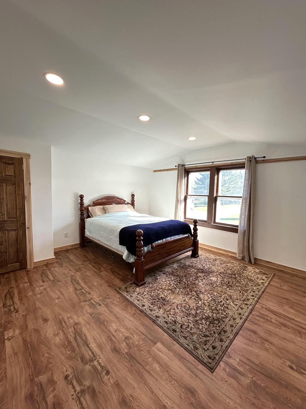 Primary bedroom with carved wood bed frame