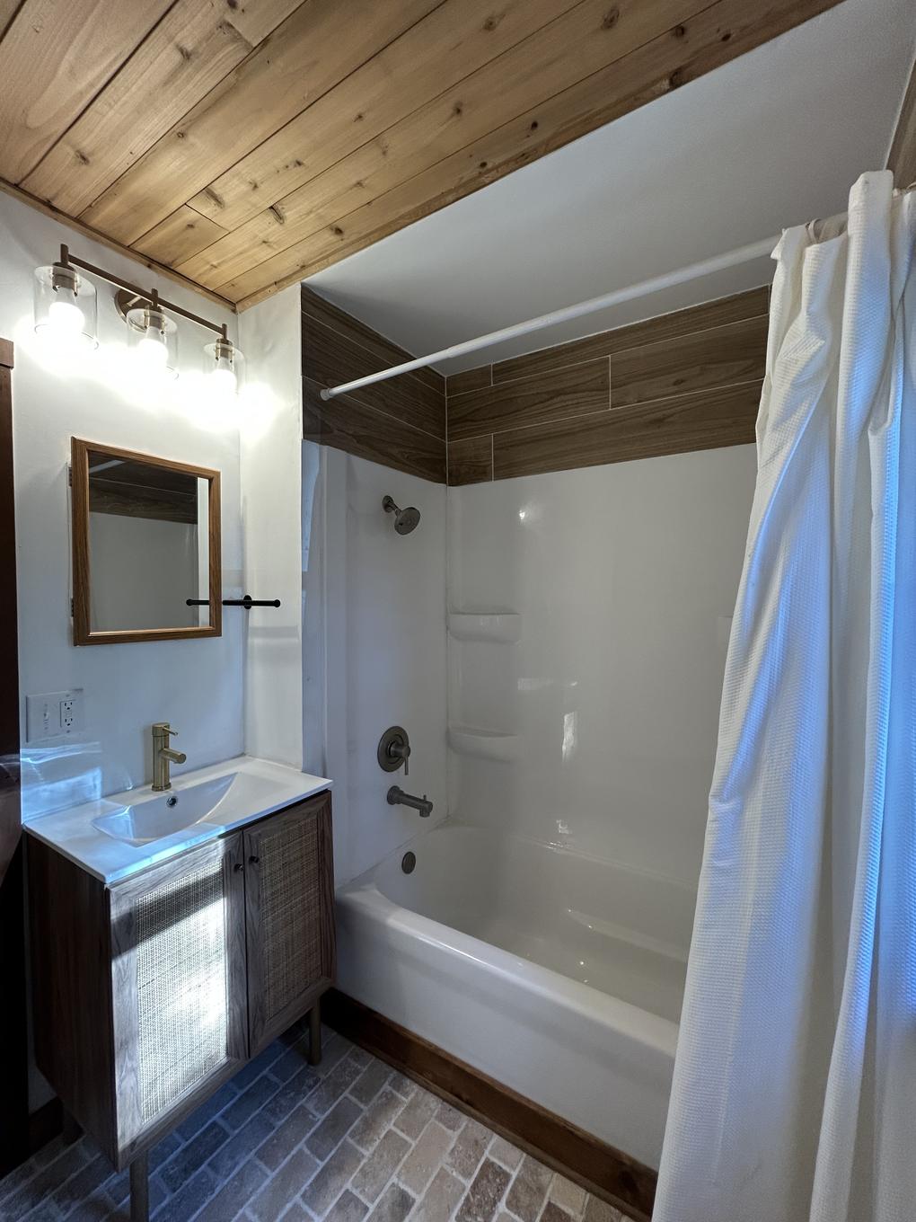 Primary bathroom with soaking tub and walnut vanity