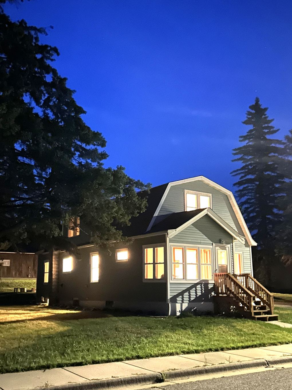 The house at dusk with lights on in every window
