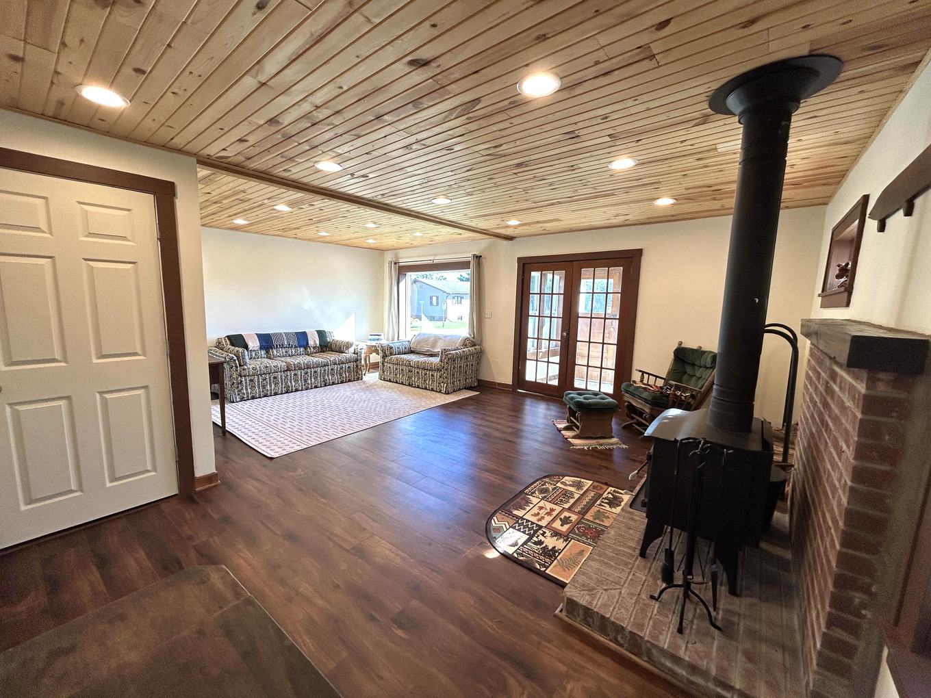 Living room from the entry, wood stove and brick chimney
