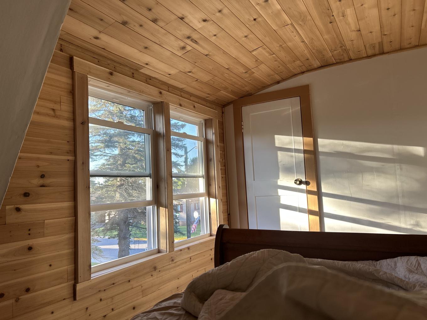 Upstairs bedroom nook with pine plank walls