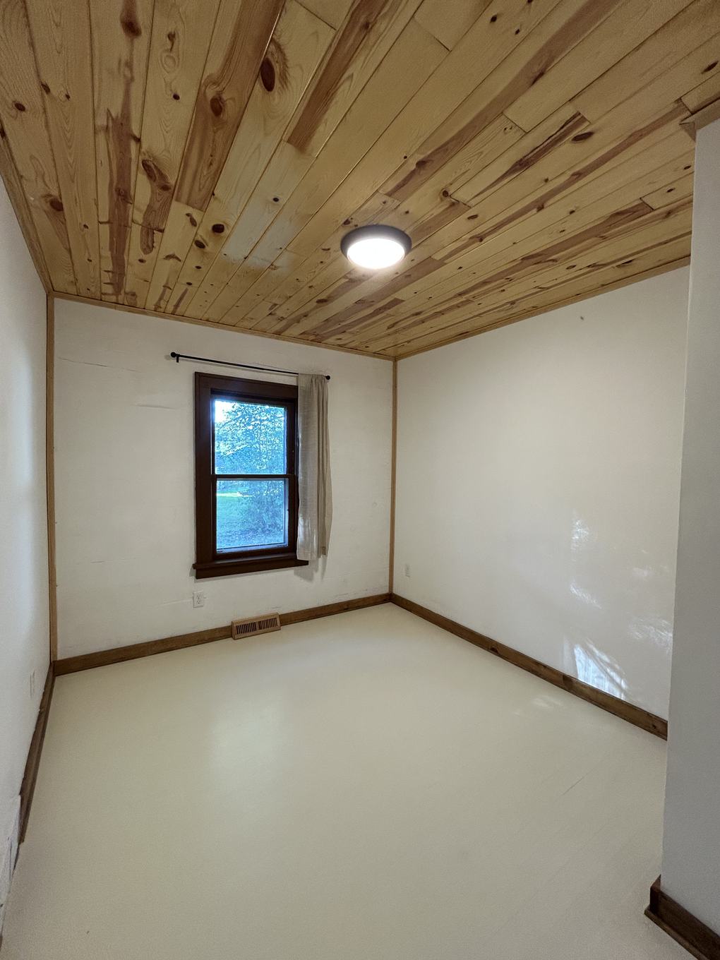 Empty upstairs bedroom nook with a full pine accent wall