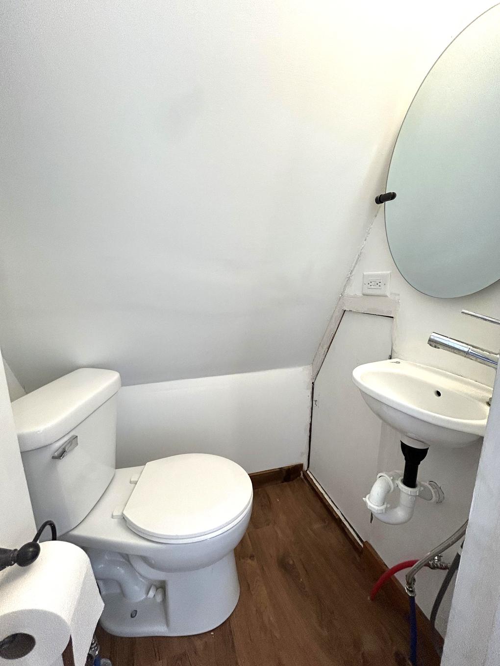 Half bathroom with pedestal-style sink and mirror