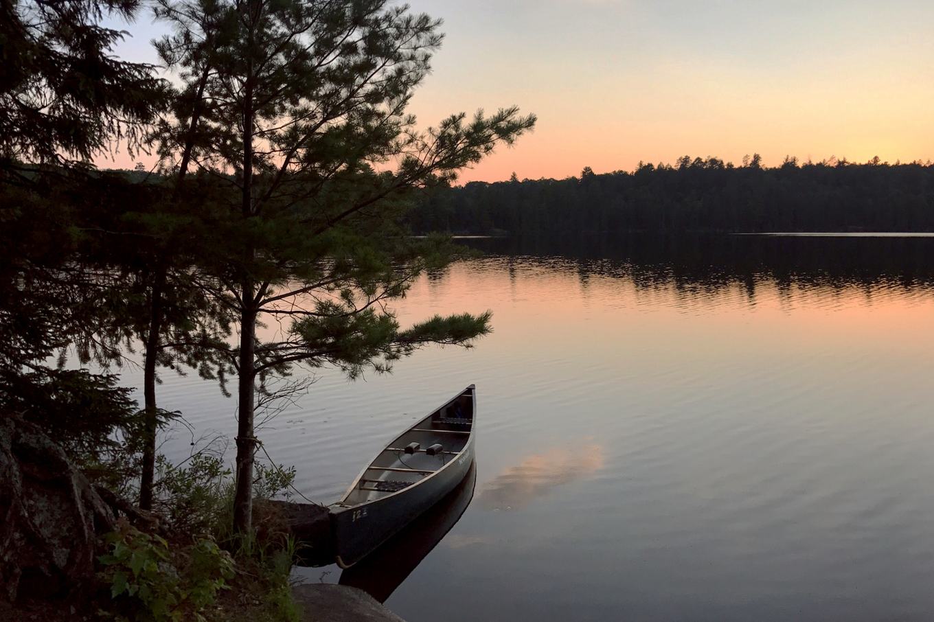 A canoe resting on shore at dusk on a Boundary Waters lake